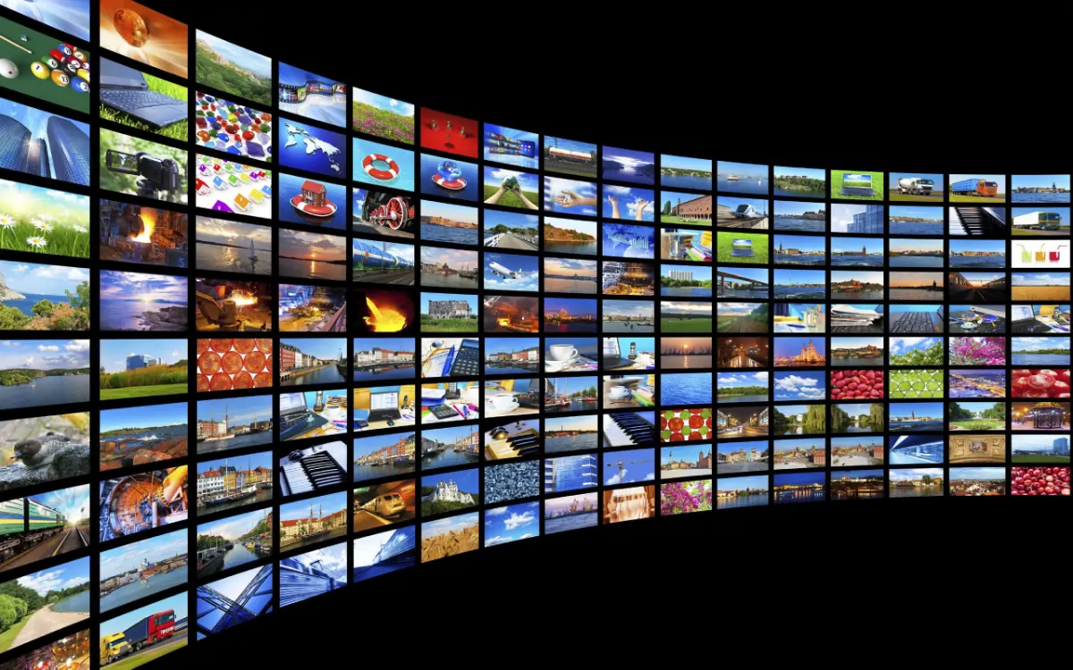 A curved wall of TV screens showing hundreds of live channels