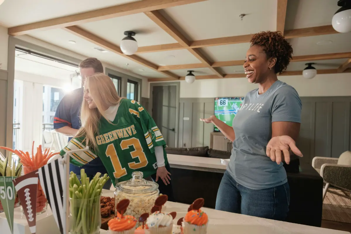 Friends celebrating while watching a football game on TV at home